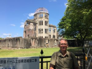 SR Staley standing before the iconic image of the atomic bomb's aftermath: the A-Bomb Dome.